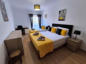 a bedroom with a large bed with a yellow blanket at Santa Rita Guest House in Olhão