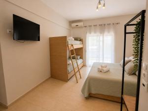 a bedroom with a bed and a tv on a wall at Aurora Apartments Stavros in Stavros