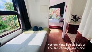 a room with a bed and a window with two beds at Myhomereservation Flores Daqui Lodge Colares Sintra in Colares