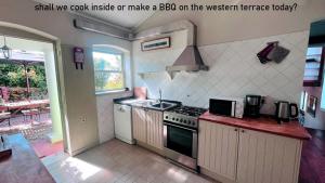 a kitchen with a sink and a stove top oven at Myhomereservation Flores Daqui Lodge Colares Sintra in Colares