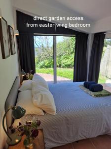 a bedroom with a large bed with a window at Myhomereservation Flores Daqui Lodge Colares Sintra in Colares