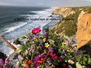 a bouquet of flowers on a cliff overlooking the ocean at Myhomereservation Flores Daqui Lodge Colares Sintra in Colares