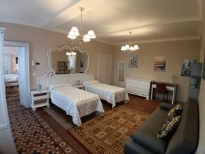 a bedroom with two beds and a mirror and a couch at La Corte della Musica in Roppolo