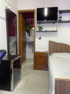 a bedroom with a bed and a sink and a mirror at Hostel Recanto Verde - Conforto e Tranquilidade em Campo Grande in Campo Grande