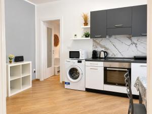 a kitchen with a washing machine and a washer at Da Nonno Eddie - tranquillo bilocale - wi-fi - tv - parcheggio vicino in Trieste