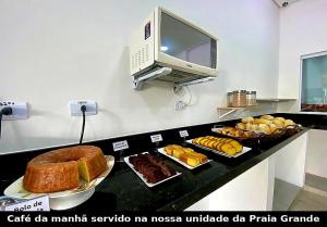 a buffet with various types of food on a counter at Mar Suites Tenório in Ubatuba