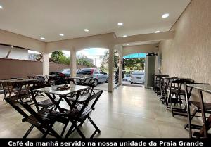 a restaurant with tables and chairs and a parking garage at Mar Suites Tenório in Ubatuba