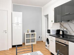 a white kitchen with a stove and a microwave at Da Nonno Eddie - tranquillo bilocale - wi-fi - tv - parcheggio vicino in Trieste +4 photos