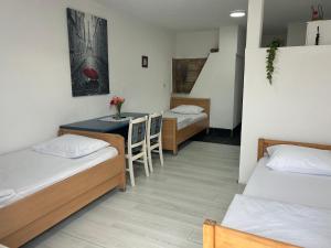 a room with two beds and a table with chairs at Apartmani BALKAN in Sjenica