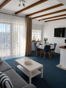a living room with a couch and a table at Apartamenty Na Fali in Jastarnia