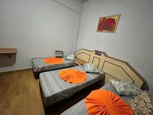 a room with three beds with orange pillows at Casarão da Sé in São Paulo