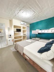 a bedroom with two beds and a blue wall at Pousada Nossa Natal in Natal +49 photos