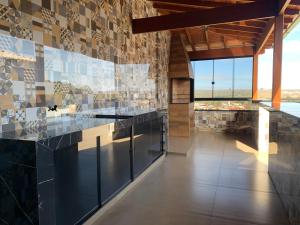 a kitchen with black countertops and a tile wall at Casa 161 in Diamantina
