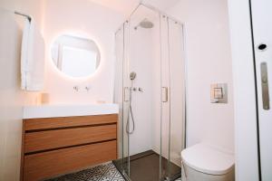 a bathroom with a shower and a toilet and a sink at Micah's Biscainhos Apartment by Quantique in Braga +22 photos