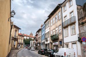 a city street with buildings and cars parked on the street at Micah's Biscainhos Apartment by Quantique in Braga