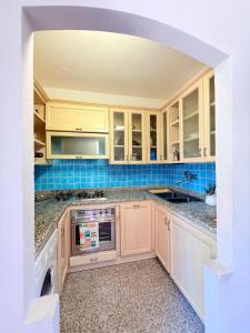 a kitchen with white cabinets and a dishwasher at Al porto in Àrbatax
