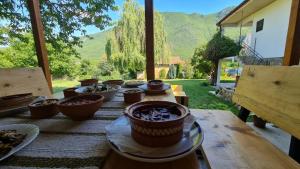 a wooden table with bowls of food on top of it at ILIS House Matka Canyon - 2 in Skopje +3 photos