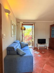 a blue couch in a living room with a television at Al porto in Àrbatax
