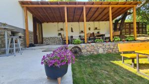 a patio with a wooden pavilion with purple flowers at ILIS House Matka Canyon - 2 in Skopje