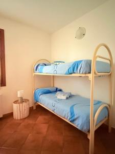 two bunk beds in a room with a lamp at Al porto in Àrbatax