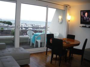 阿爾卡雄的住宿－Les Huniers，客厅配有桌子,享有海港的景色