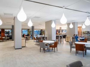 eine Lobby mit Tischen, Stühlen und Beleuchtung in der Unterkunft Novotel The Hague World Forum in Den Haag