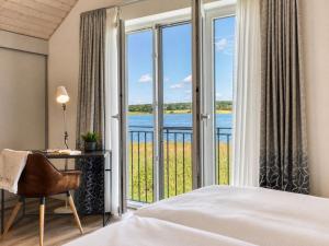 a bedroom with a bed and a desk and a window at Ferienhaus Neukamp 17D Schilfhütte in Putbus