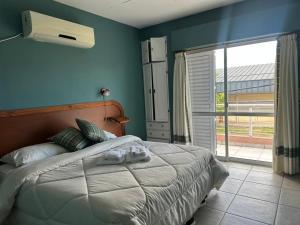 a bedroom with a bed with blue walls and a window at Lass Cahuelas in Federación
