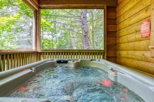 a hot tub in a cabin with a window at Precious Moments in Sevierville