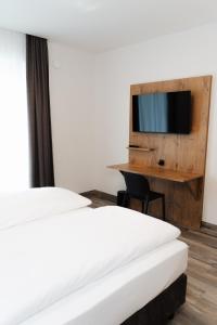 a hotel room with two beds and a tv at ML Business Hotel - Self-Check-in in Lannach