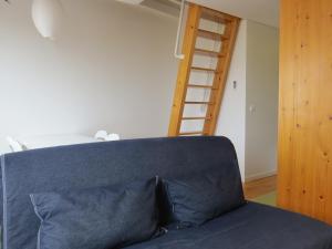 a blue couch in a room with a ladder at Tagus Apartments by Lisbon Village Apartments in Lisbon