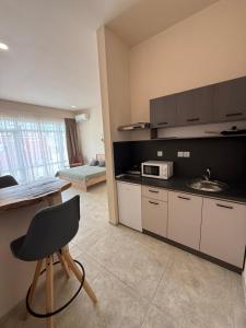 a kitchen with a table and a sink and a microwave at NM Residence 2 in Shkorpilovtsi +15 photos