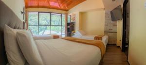 a hotel room with two beds and a window at Hotel Raices Machupicchu in Machu Picchu +69 photos