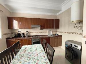 a kitchen with a table and chairs and a table and a table and a kitchen at Casandalus in Larache