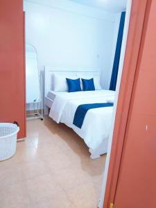 a bedroom with a white bed with blue pillows at Nest homes in Eldoret