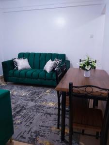a green couch in a living room with a table at Nest homes in Eldoret