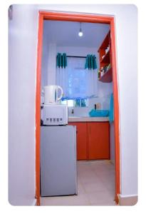 a kitchen with a refrigerator and a microwave at Nest homes in Eldoret