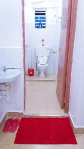 a bathroom with a toilet and a red rug at Nest homes in Eldoret