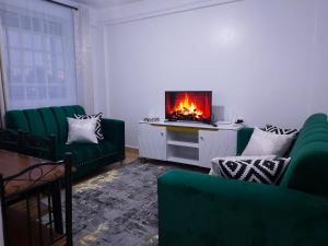 a living room with green couches and a fireplace at Nest homes in Eldoret