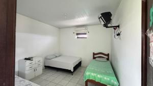 a small room with a bed and a small table at Pousada Zambaiam in Torto