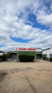 a building with a sign that reads pussota zambian at Pousada Zambaiam in Torto