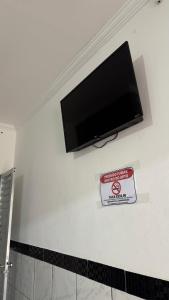 a flat screen tv on a wall with a sign at Pousada Zambaiam in Torto +33 photos