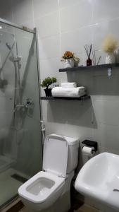 a bathroom with a toilet and a shower and a sink at Olivewood Apartments in Ankuru +10 photos