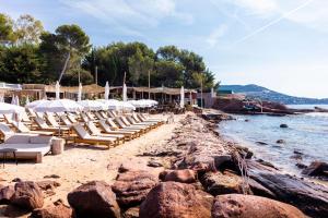 a beach with chairs and umbrellas and the water at La Réserve Esterel in Saint-Raphaël +95 photos