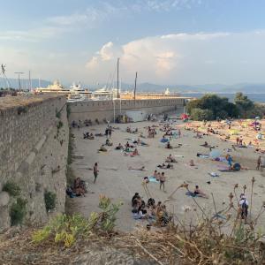 a crowd of people on a beach near a pier at Escapade Antiboise avec parking inclus in Antibes