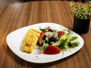 a plate of food with a salad on a table at ibis Betim in Contagem +75 photos