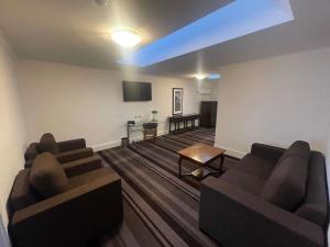 a living room with two couches and a flat screen tv at Mercure Canberra in Canberra