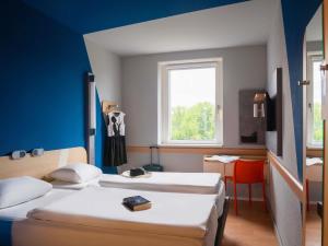 a room with two beds and a window at ibis budget Berlin Alexanderplatz in Berlin +23 photos