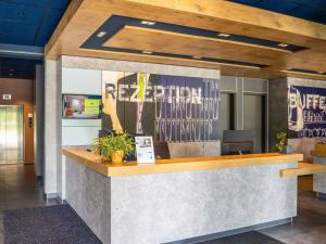 an office lobby with a reception counter with a sign at ibis budget Berlin Alexanderplatz in Berlin