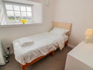 a small bedroom with a bed and a window at The Old Coach House in Lockerbie